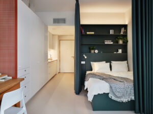 Studio apartment bedroom with a privacy curtain designed by Holky rády architekturu at Fellows Jaselská.