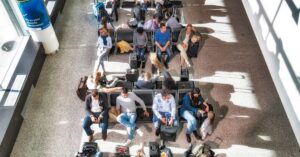 Passengers with luggage waiting at the airport, reflecting long queues at Prague airport passport control